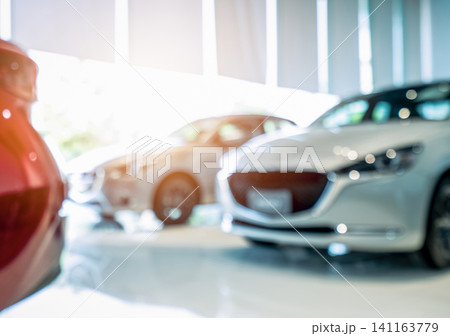 Blurred front view of white car. Luxury car parked in modern showroom. Car dealership office. Electric car business concept. Automobile leasing. Automotive industry crisis impact from coronavirus. Blurred front view of white car. Luxury car parked in modern showroom. Car dealership office. Electric car business concept. Automobile leasing. Automotive industry crisis impact from coronavirus. 141163779
