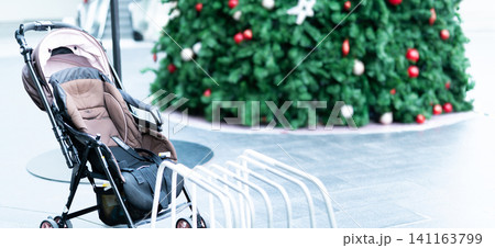 Empty baby stroller parked at outdoor area of shopping mall. Child pram stroller for baby transportation to travel with family. Baby carriage. Activity outside home with child. Abandoned child pram. 141163799