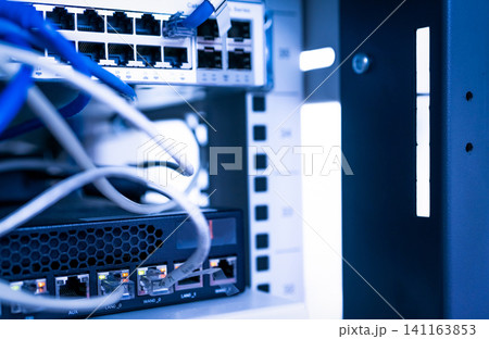 Network switch and ethernet cable in data center. Wifi plug of internet router for computer. Network hub. Communication networking wireless. Network switch and ethernet optic fiber cable in the rack. Network switch and ethernet cable in data center. Wifi plug of internet router for computer. Network hub. Communication networking wireless. Network switch and ethernet optic fiber cable in the rack. 141163853