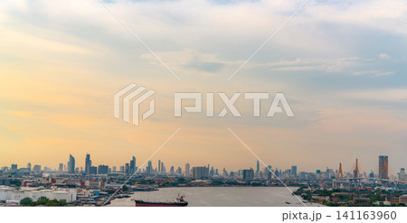 Cityscape of modern building and river with orange and blue sky. Skyscraper building. Urban skyline. Capital city in the evening with sunset sky. Crowded of skyscraper building in downtown district. 141163960
