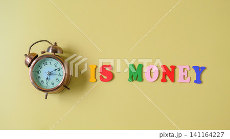 Vintage alarm clock with Time Is Money text on background. 141164227