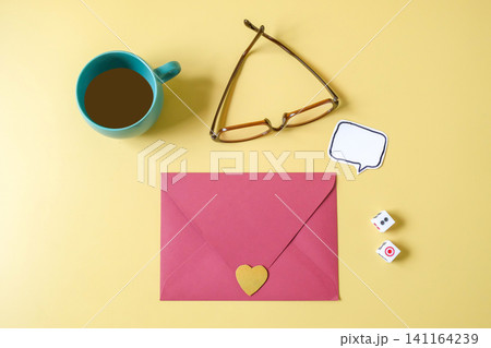 Pink paper envelope with mini heart sign on a color background. Pink paper envelope with mini heart sign on a color background. 141164239