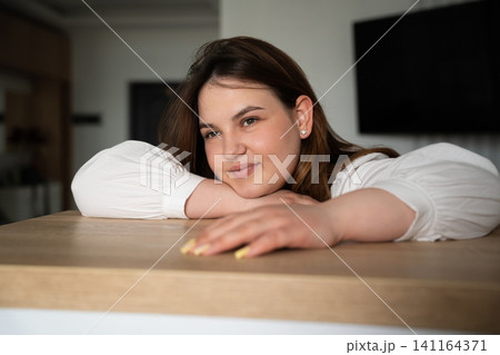 Young woman resting her head on a table at home office looking fatigued. Remote work fatigue and burnout stress in a home environment Young woman resting her head on a table at home office looking fatigued. Remote work fatigue and burnout stress in a home environment 141164371