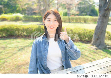 公園でグッドサインをする日本人女性 141164416