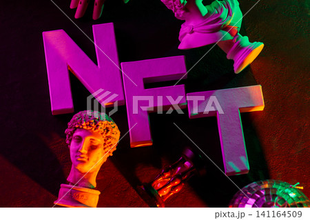 Large pink NFT letters with classical sculpture busts and vibrant neon lighting concept Large pink NFT letters with classical sculpture busts and vibrant neon lighting concept 141164509
