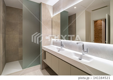 Modern bathroom interior with double sinks sleek faucets and glass shower in neutral tones and contemporary design, with bathroom, interior, modern, contemporary detail Modern bathroom interior with double sinks sleek faucets and glass shower in neutral tones and contemporary design, with bathroom, interior, modern, contemporary detail 141164521