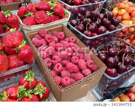 Fresh raspberries, cherries and strawberries displayed in market crates with seasonal berries ready for purchase. Healthy nutrition, local farming, grocery retail, agriculture, harvest, summer produce Fresh raspberries, cherries and strawberries displayed in market crates with seasonal berries ready for purchase. Healthy nutrition, local farming, grocery retail, agriculture, harvest, summer produce 141164753