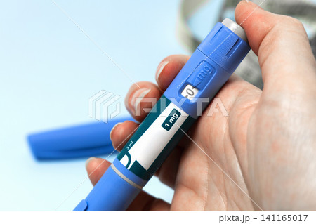 Hand holding Ozempic injection pen for diabetes treatment. 141165017