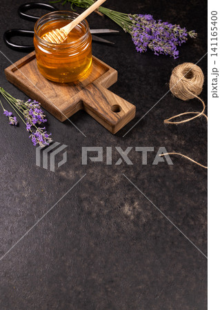 Honey jar with lavender flowers on wooden board Honey jar with lavender flowers on wooden board 141165400