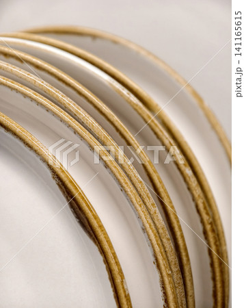 White ceramic plates with yellow rim, very close up showing beautiful dishes for kitchen and home 141165615