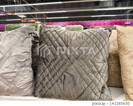 Decorative pillows on supermarket shelves creating an attractive display of soft furnishings for home decoration and interior design 141165650