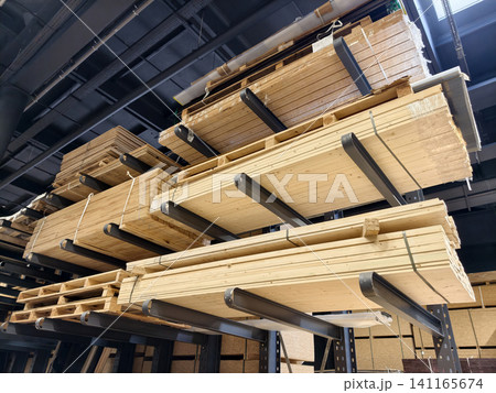 Industrial storage racks hold neatly stacked MDF boards, OSB sheets, particle boards and wooden planks inside a modern timber processing warehouse environment Industrial storage racks hold neatly stacked MDF boards, OSB sheets, particle boards and wooden planks inside a modern timber processing warehouse environment 141165674