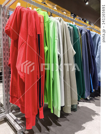 Bright hoodies hanging in a sporting goods store present a neat selection of everyday comfortable clothing 141165691