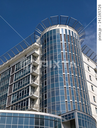 Contemporary apartment tower with glass windows and balconies located in a developing city neighborhood 141165726