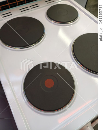 Sleek modern electric stove with four burners in white Sleek modern electric stove with four burners in white 141165752