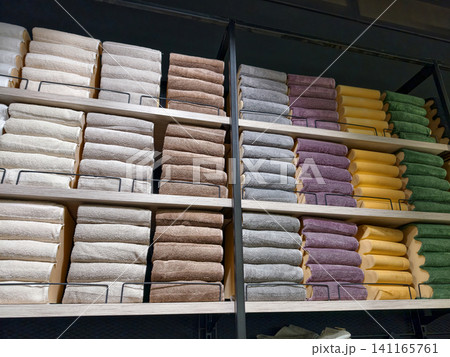 Cotton towels in bright colors displayed on spacious shelves in hypermarket Cotton towels in bright colors displayed on spacious shelves in hypermarket 141165761