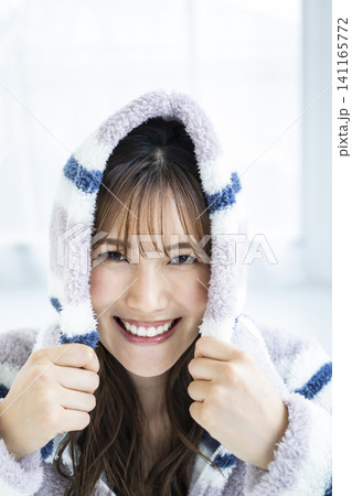 フードをかぶってはしゃぐ若い女性 フードをかぶってはしゃぐ若い女性 141165772