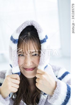 フードをかぶってはしゃぐ若い女性 フードをかぶってはしゃぐ若い女性 141165778