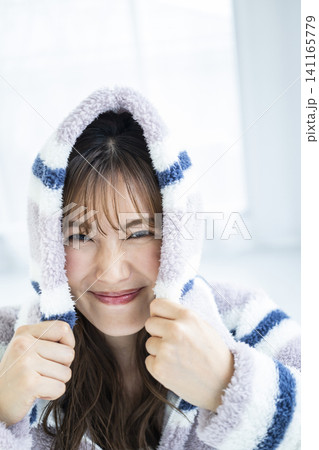 フードをかぶってはしゃぐ若い女性 フードをかぶってはしゃぐ若い女性 141165779