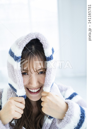 フードをかぶってはしゃぐ若い女性 フードをかぶってはしゃぐ若い女性 141165781