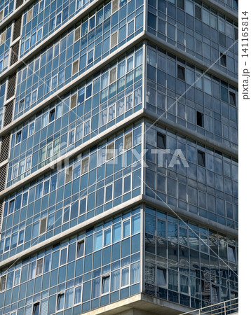 Residential skyscraper with stylish modern facade rising above surrounding urban buildings 141165814
