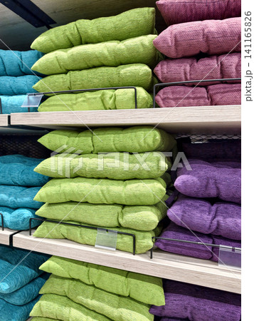 Colorful seat cushions in blue green and purple tones showcased together on supermarket shelves with organized chair pads and soft textile seating items Colorful seat cushions in blue green and purple tones showcased together on supermarket shelves with organized chair pads and soft textile seating items 141165826