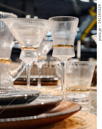 Crystal clear drinking glasses shine beautifully on an opulent dining table setting Crystal clear drinking glasses shine beautifully on an opulent dining table setting 141165829