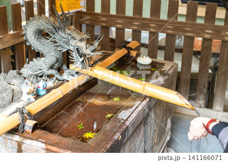 神社の手水舎で手を清める人の手 神社の手水舎で手を清める人の手 141166071