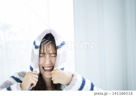 フードをかぶってはしゃぐ若い女性 フードをかぶってはしゃぐ若い女性 141166518