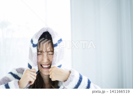 フードをかぶってはしゃぐ若い女性 フードをかぶってはしゃぐ若い女性 141166519