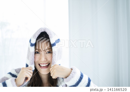 フードをかぶってはしゃぐ若い女性 フードをかぶってはしゃぐ若い女性 141166520