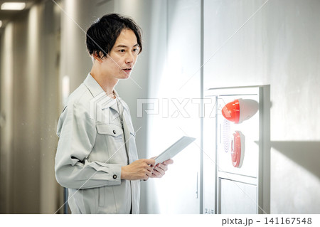 火災報知器の点検をする作業服の男性 火災報知器の点検をする作業服の男性 141167548