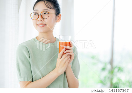 トマトジュースを飲む若い女性 トマトジュースを飲む若い女性 141167567