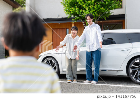 マイホームと愛車の前で子供を迎え入れる夫婦 マイホームと愛車の前で子供を迎え入れる夫婦 141167756