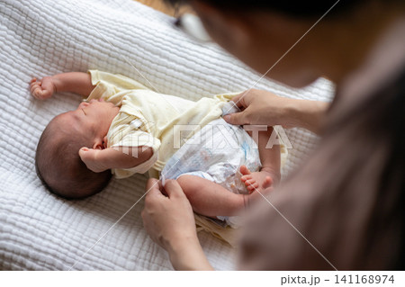 新生児のオムツを替えているところ 新生児のオムツを替えているところ 141168974