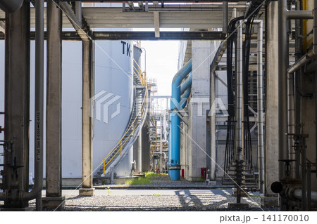 Industrial plant corridor with storage tanks, piping, and process infrastructure 141170010