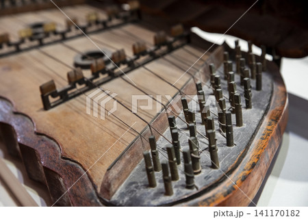 Close-up of the intricate strings and wooden body of a Dan Tam Thap Luc, a traditional Vietnamese hammered dulcimer Close-up of the intricate strings and wooden body of a Dan Tam Thap Luc, a traditional Vietnamese hammered dulcimer 141170182