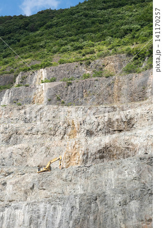 巨大な岩壁とショベルカーがある石灰石採石場の風景1 巨大な岩壁とショベルカーがある石灰石採石場の風景1 141170257