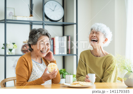 友達とせんべいを食べるシニアの女性 友達とせんべいを食べるシニアの女性 141170385