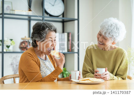 友達とせんべいを食べるシニアの女性 友達とせんべいを食べるシニアの女性 141170387