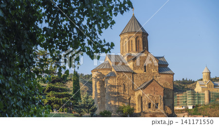Ancient Metekhi church in old Tbilisi at sunset with leaves framing and copy space Ancient Metekhi church in old Tbilisi at sunset with leaves framing and copy space 141171550