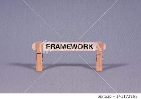 Framework symbol. Single Wooden stick restrained by Clothespins, beautiful Gray Background. Business and Framework concept with copy space Framework symbol. Single Wooden stick restrained by Clothespins, beautiful Gray Background. Business and Framework concept with copy space 141172165