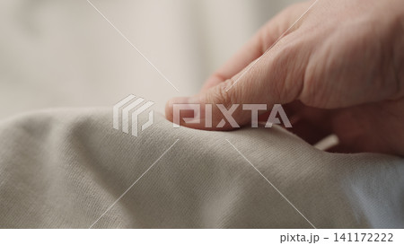 man manually check ivory color cotton fabric for clothing with hands man manually check ivory color cotton fabric for clothing with hands 141172222