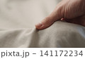 man manually check ivory color cotton fabric for clothing with hands 141172234
