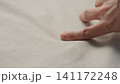man manually check ivory color cotton fabric for clothing with hands 141172248