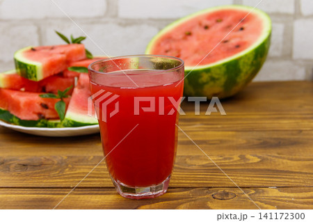 Glass of fresh watermelon juice on a wooden table Glass of fresh watermelon juice on a wooden table 141172300