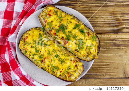 Baked stuffed eggplants on a wooden table. Top view. Healthy food and dieting concept 141172304