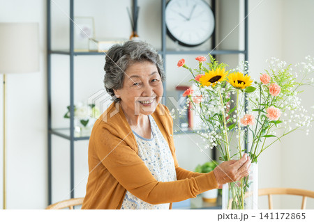 家で花を生けるシニアの女性 家で花を生けるシニアの女性 141172865
