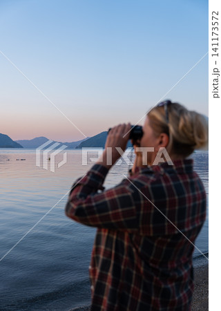 Woman Looking Through Binoculars on Marmaris Waterfront at Golden Hour Woman Looking Through Binoculars on Marmaris Waterfront at Golden Hour 141173572
