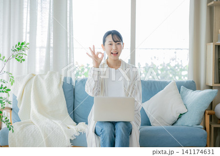 ソファーでノートパソコンを使う女性 ソファーでノートパソコンを使う女性 141174631
